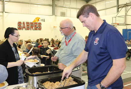 Cherry Coulee principal, Mike Daniels (front) and teacher, Craig Funston serve up supper at the school's fall fundraiser on Friday evening.