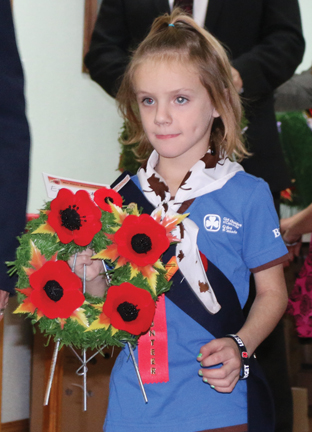 Proudly dressed in her Brownie uniform, Shelbi Walsh delivers a wreath to the cenotaph. 