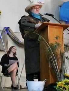 Photo by Jamie Rieger- Fr. Fred Monk surprised the graduates by giving a humorous, western-themed address at their graduation ceremony on Saturday evening.
