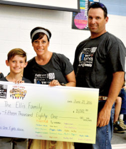 Photo by Tim Kalinowski- The Seven Persons School Grade 5/6 class successfully sold 1,270 "Team Tanya" T-shirts and raised over $28,000 during the campaign. Pictured: Tanya and Tim Ellis accept a cheque from Rylan Dent for $15,081. The donation will help with Tanya's cancer fight. 