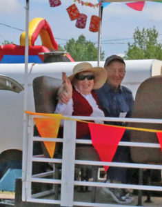 Photo by Jamie Rieger- Helen Flaig and Orion's Boyd stevens ride on the shuttle through the parade route.