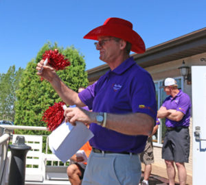 Photo by Jamie Rieger- Robin Knibbs gets out the pom-poms to encourage golfers to cheer in honour of Sue Andersen.
