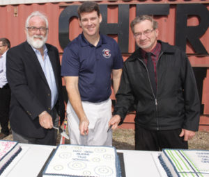Photo by Jamie Rieger- CCCA principal, Mike Daniels (centre), is joiined by Koinonia Schools superintendent, Vern Rand and assistant superintendent, Garry Anderson for the cutting of the cakes.