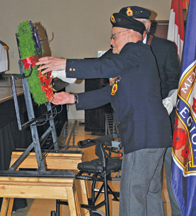Photo by Jamie Rieger WWII veteran Ralph Lee (96 years old) places a wreath during the service in Foremost. 